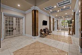 a large lobby with doors and chairs and a tv